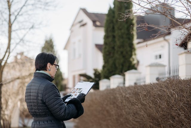 Standing on the Street while Holding a House Plan