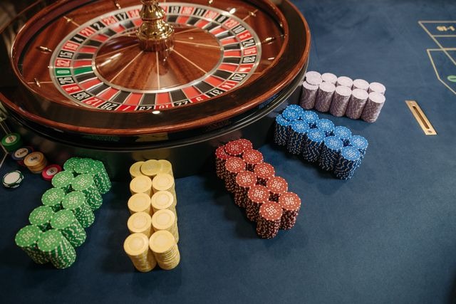 poker chips stacked beside a roulette wheel