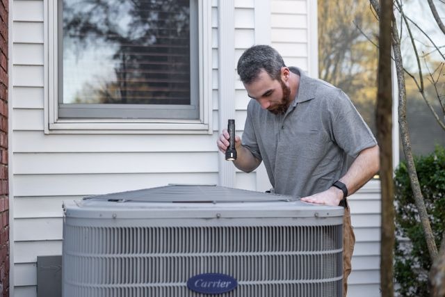 a person outside inspecting an hvac unit