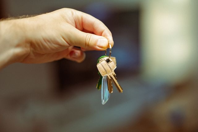 hand holding a keyring with several house keys