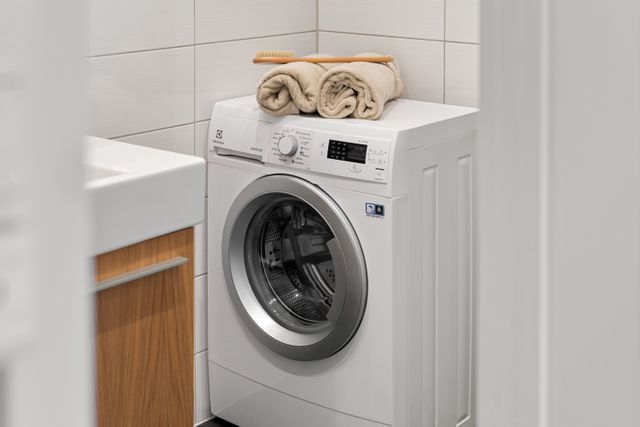 laundry space featuring a white washing machine